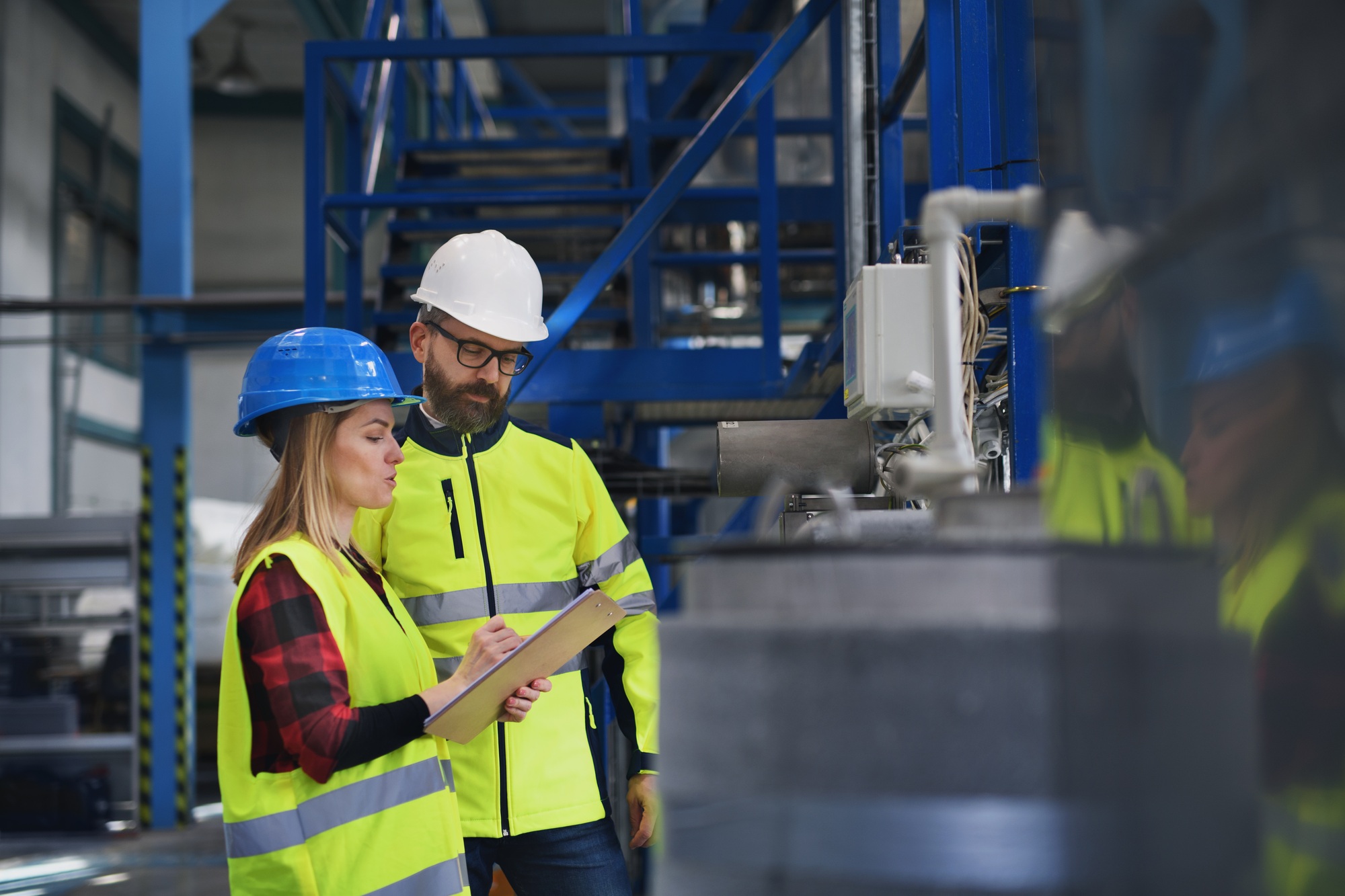 Engineering manager and mechanic worker doing routine check up in industrial factory
